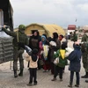 Phát hàng cứu trợ cho người dân Syria ở Abu Duhur, tỉnh Idlib. (Ảnh: AFP/TTXVN)