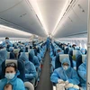 Tất cả hành khách được phát và phải mặc đồ bảo hộ trong suốt chuyến bay từ Vương quốc Anh về Việt Nam. (Ảnh: TTXVN phát)