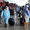 Hành khách đeo khẩu trang và mặc quần áo bảo hộ phòng lây nhiễm COVID-19 tại sân bay quốc tế Indira Gandhi ở New Delhi, Ấn Độ. (Ảnh: THX/TTXVN)