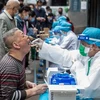 Nhân viên y tế lấy mẫu dịch xét nghiệm COVID-19 cho người dân tại Vũ Hán, tỉnh Hồ Bắc, Trung Quốc. (Ảnh: AFP/ TTXVN)
