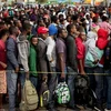 Người di cư xếp hàng bên ngoài một văn phòng di trú ở Tijuana, Mexico để đăng ký nhập cư vào Mỹ. (Ảnh: AFP/TTXVN)