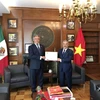 Đại sứ đặc mệnh toàn quyền Việt Nam tại Liên bang Mexico Nguyễn Hoài Dương trao quyết định cho ông Miguel Angel Landeros Voquart. (Ảnh: Lưu Việt Hùng/TTXVN)