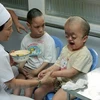 Nữ nhân viên Làng Hòa Bình-Từ Dũ, Thành phố Hồ Chí Minh tận tình chăm sóc trẻ bị di chứng chất độc da cam/dioxin. (Ảnh: Dương Ngọc/TTXVN)