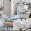 Công nhân sản xuất khẩu trang tại một nhà máy ở tỉnh Giang Tô, miền Đông Trung Quốc. (Ảnh: AFP/TTXVN)