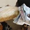 Người dân trả tiền để mua bánh mì tại Harare, Zimbabwe. (Ảnh: AFP/TTXVN)