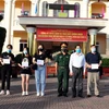 Lãnh đạo Ủy ban Nhân dân tỉnh Sóc Trăng và Bộ chỉ huy Quân sự tỉnh Sóc Trăng trao chứng nhận hoàn thành cách ly cho các công dân. (Ảnh: Trung Hiếu/TTXVN)