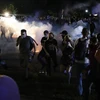 Người biểu tình xung đột với cảnh sát trong cuộc tuần hành phản đối vụ cảnh sát bắn người da màu tại Kenosha, bang Wisconsin (Mỹ). (Ảnh: AFP/TTXVN)