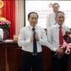 Ông Lê Tiến Châu, Chủ tịch UBND tỉnh Hậu Giang (bên trái) tặng hoa cho ông Lữ Văn Hùng. (Ảnh: Duy Khương/TTXVN)