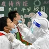 Nhân viên y tế lấy mẫu xét nghiệm COVID-19 cho người dân tại tỉnh Hà Bắc, Trung Quốc. (Ảnh: AFP/TTXVN)