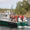 Hành khách được sơ tán từ phà bị mắc cạn tại một đảo trên biển Baltic. (Ảnh: AFP/TTXVN)
