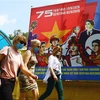 Du khách quốc tế đeo khẩu trang, dạo bộ trên phố Điện Biên Phủ. (Ảnh: Lâm Khánh/TTXVN)
