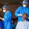 Nhân viên y tế lấy mẫu dịch xét nghiệm COVID-19 cho người dân tại New Delhi, Ấn Độ. (Ảnh: AFP/TTXVN)