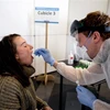 Nhân viên y tế lấy mẫu xét nghiệm COVID-19 tại Leuven, Bỉ. (Ảnh: AFP/TTXVN)