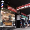 Người dân xếp hàng bên ngoài một tiệm cắt tóc tại Melbourne, Australia. (Ảnh: AFP/TTXVN)