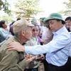 Thủ tướng Nguyễn Xuân Phúc thăm hỏi, chia sẻ khó khăn, mất mát với nhân dân thôn Đồng Tư, xã Hiền Ninh, huyện Quảng Ninh, tỉnh Quảng Bình. (Ảnh: Thống Nhất/TTXVN)