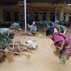 Bộ đội giúp địa phương xã Hướng Việt thu dọn bùn đất tại trường học. (Ảnh: Hồ Cầu/TTXVN)