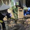 Lực lượng quân đội và đoàn thanh niên dọn dẹp vệ sinh tại thị trấn La Hai, huyện Đồng Xuân. (Ảnh: Xuân Triệu/TTXVN)