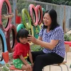 Cô giáo Lê Thị Loan chăm sóc, chải tóc cho học sinh của mình. (Ảnh: Xuân Tiến/TTXVN)
