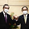 Thủ tướng Nhật Bản Suga Yoshihide (phải) và Bộ trưởng Ngoại giao Trung Quốc Vương Nghị (trái) tại cuộc gặp ở Tokyo, Nhật Bản. (Ảnh: AFP/TTXVN)