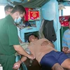Quân y Bộ đội Biên phòng Sóc Trăng thăm khám sức khoẻ ban đầu cho 2 ngư dân gặp nạn. (Ảnh: Trung Hiếu/TTXVN)