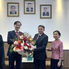 Đại sứ Nguyễn Tất Thành tặng hoa chúc mừng Đại sứ Lào Sisavath Inphachanh. (Ảnh: Nguyễn Minh/Vietnam+)