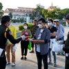 Lực lượng quân cảnh Campuchia phát khẩu trang miễn phí cho người dân tại Phnom Penh. (Ảnh: AFP/TTXVN)