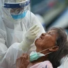 Nhân viên y tế lấy mẫu dịch xét nghiệm COVID-19 cho người dân tại tỉnh Samut Sakhon, Thái Lan. (Ảnh: THX/TTXVN)