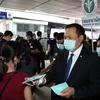 Phó Thủ tướng kiêm Bộ trưởng Y tế Thái Lan Anutin Charnvirakul (phải) phát khẩu trang cho hành khách tại một nhà ga ở Bangkok hồi tháng 2/2020. (Ảnh: AFP/TTXVN)