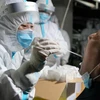 Nhân viên y tế lấy mẫu dịch xét nghiệm COVID-19 cho người dan tại Thạch Gia Trang, tỉnh Hà Bắc, Trung Quốc. (Ảnh: THX/TTXVN)