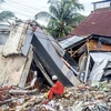 Lực lượng cứu hộ tìm kiếm nạn nhân dưới đống đổ nát của tòa nhà bị sập sau trận động đất ở Mamuju, Tây Sulawesi, Indonesia ngày 16/1. (Ảnh: THX/TTXVN)