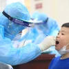 Nhân viên y tế quận Nam Từ Liêm tiến hành hành lấy mẫu xét nghiệm test nhanh COVID-19 cho các em học sinh trường Tiểu học Xuân Phương. (Ảnh: Thành Đạt/TTXVN)