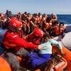 Các thành viên tổ chức cứu trợ Tây Ban Nha giải cứu người di cư trôi dạt ngoài khơi bờ biển Libya. (Ảnh: AFP/TTXVN)
