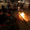 Người dân quây quần bên đống lửa để sưởi ấm. (Ảnh: Phan Tuấn Anh/TTXVN)