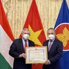 Đại sứ Nguyễn Tiến Thức trao Bằng khen của Bộ trưởng Ngoại giao cho Hội Hữu nghị Hungary-Việt Nam. (Ảnh: Đại sứ quán Việt Nam tại Hungary)