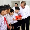 Phó Thủ tướng Thường trực Trương Hòa Bình trao tặng quà cho các trẻ khuyết tật. (Ảnh: Lê Ngọc Phước/TTXVN)