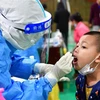 Nhân viên y tế lấy mẫu xét nghiệm COVID-19 tại tỉnh Vân Nam, Trung Quốc. (Ảnh: THX/TTXVN)