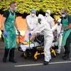 Nhân viên y tế chuyển bệnh nhân mắc COVID-19 ra xe cứu thương tại Botley, Anh. (Ảnh: AFP/TTXVN)