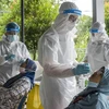Nhân viên y tế lấy mẫu xét nghiệm COVID-19 cho người dân tại Ampang, gần Kuala Lumpur, Malaysia. (Ảnh: THX/TTXVN)