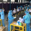 Các y bác sỹ Trung tâm kiểm soát bệnh tật Thành phố Hồ Chí Minh và Quận 7 thực hiện xét nghiệm sàng lọc COVID-19 ngẫu nhiên cho công nhân ở Khu chế xuất Tân Thuận. (Ảnh: Thanh Vũ/TTXVN)