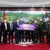 Phó Thủ tướng, Bộ trưởng Quốc phòng Lào trao số tiền 200.000 USD ủng hộ Quỹ phòng, chống COVID-19 của Việt Nam cho Đại sứ Việt Nam tại Lào Nguyễn Bá Hùng. (Ảnh: Phạm Kiên/TTXVN)