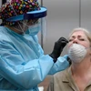 Nhân viên y tế lấy mẫu dịch xét nghiệm COVID-19 cho người dân tại Mỹ. (Ảnh: AFP/TTXVN)