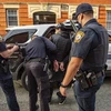 Cảnh sát Mỹ khám xét bắt giữ một nghi phạm. (Ảnh: AFP/TTXVN)