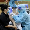Nhân viên y tế tiêm vaccine cho người dân tại Nhà thi đấu Lãnh Binh Thăng (Quận 11, Thành phố Hồ Chí Minh). (Ảnh: Hồng Giang/TTXVN)