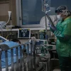 Nhân viên y tế điều trị cho bệnh nhân COVID-19 tại bệnh viện thành phố Yokohama, Nhật Bản. (Ảnh: AFP/TTXVN)