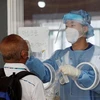 Nhân viên y tế lấy mẫu xét nghiệm COVID-19 tại Seoul, Hàn Quốc. (Ảnh: Yonhap/TTXVN)