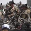 Binh sỹ Mỹ đảm bảo an ninh khi dòng người Afghanistan sơ tán lánh nạn đổ về tuyến đường gần khu quân sự của sân bay quốc tế Kabul. (Ảnh: AFP/TTXVN)