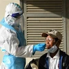 Nhân viên y tế lấy mẫu xét nghiệm COVID-19 cho người dân tại Phnom Penh, Campuchia. (Ảnh: AFP/TTXVN)