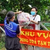 Trao túi an sinh cho người dân khu vực phong tỏa. (Ảnh: Xuân Khu/TTXVN)