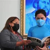 Bà Teresa Amarelle Boué trao tặng bà Hà Thị Nga cuốn sách về truyền thống Hội Liên hiệp Phụ nữ Cuba. (Ảnh: Vũ Hà/TTXVN)