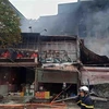 Hiện trường vụ cháy tại địa chỉ ở số 63 Nguyễn Hoàng lan ra nhiều nhà xung quanh. (Ảnh: TTXVN phát)